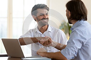 Happy businessman salesman manager handshake satisfied client at meeting photo
