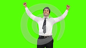 Happy businessman showing thumbs up on green background