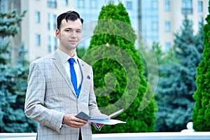 Happy businessman in suit holding business report in hands