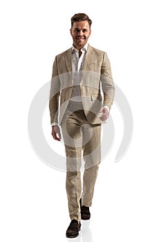Happy businessman in suit with open collar shirt walking isolated