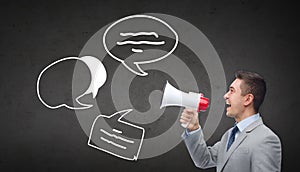 Happy businessman in suit speaking to megaphone