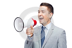 Happy businessman in suit speaking to megaphone