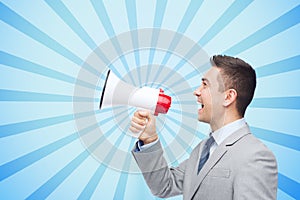 Happy businessman in suit speaking to megaphone photo