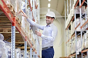 Happy businessman with tablet pc at warehouse