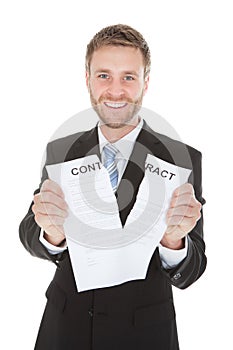 Happy businessman tearing contract paper