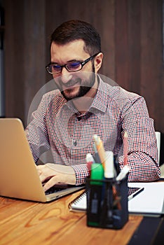 Happy businessman typing on his laptop