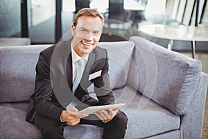 Happy businessman using digital tablet