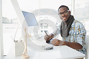 Happy businessman using digitizer at desk photo