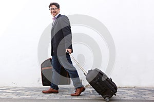 Happy businessman walking with bags along the street