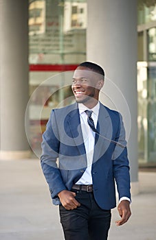 Happy businessman walking in the city