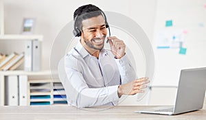 Happy businessman working in a call center. Customer service rep helping on a call. Sales agent speaking to client. IT