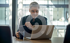 Happy businessman working with laptop in office