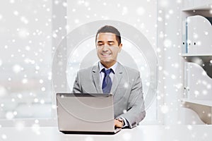 Happy businessman working with laptop in office