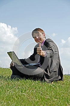 Happy businessman working with a laptop outdoor