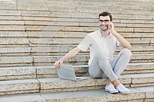 Young businessman working with laptop outdoors