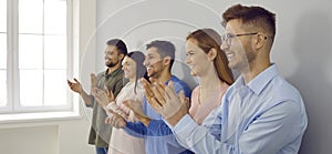 Happy businesspeople clap hands show acknowledgement photo