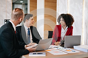 Happy businesspeople while collaborating on a new project in an office. Group of diverse businesspeople using a laptop and tablet