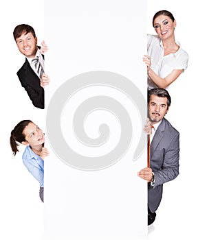 Happy businesspeople hiding behind large billboard