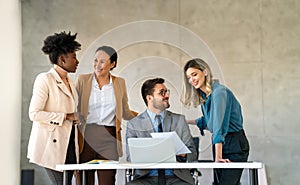 Happy businesspeople laughing while collaborating on a new project in an office.