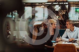 Happy businesspeople smiling cheerfully during a meeting in a coffee shop. Group of successful business professionals