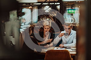 Happy businesspeople smiling cheerfully during a meeting in a coffee shop. Group of successful business professionals