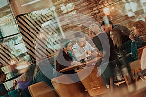 Happy businesspeople smiling cheerfully during a meeting in a coffee shop. Group of successful business professionals