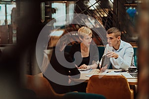 Happy businesspeople smiling cheerfully during a meeting in a coffee shop. Group of successful business professionals