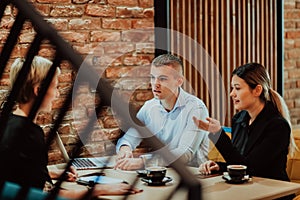 Happy businesspeople smiling cheerfully during a meeting in a coffee shop. Group of successful business professionals