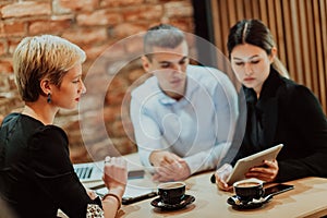 Happy businesspeople smiling cheerfully during a meeting in a coffee shop. Group of successful business professionals