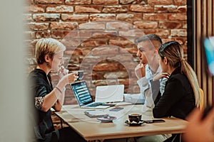 Happy businesspeople smiling cheerfully during a meeting in a coffee shop. Group of successful business professionals