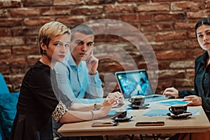 Happy businesspeople smiling cheerfully during a meeting in a coffee shop. Group of successful business professionals