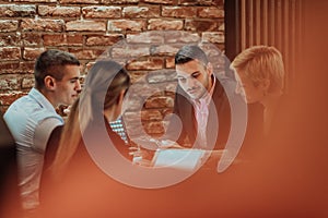 Happy businesspeople smiling cheerfully during a meeting in a coffee shop. Group of successful business professionals