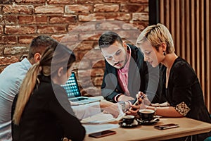 Happy businesspeople smiling cheerfully during a meeting in a coffee shop. Group of successful business professionals