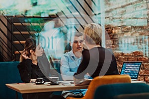 Happy businesspeople smiling cheerfully during a meeting in a coffee shop. Group of successful business professionals