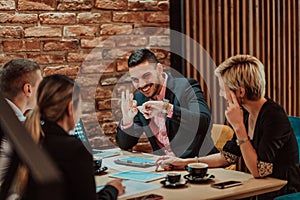 Happy businesspeople smiling cheerfully during a meeting in a coffee shop. Group of successful business professionals