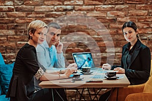 Happy businesspeople smiling cheerfully during a meeting in a coffee shop. Group of successful business professionals