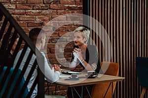 Happy businesspeople smiling cheerfully during a meeting in a coffee shop. Group of successful business professionals