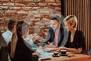 Happy businesspeople smiling cheerfully during a meeting in a coffee shop. Group of successful business professionals