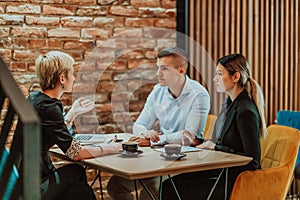 Happy businesspeople smiling cheerfully during a meeting in a coffee shop. Group of successful business professionals