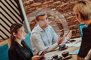 Happy businesspeople smiling cheerfully during a meeting in a coffee shop. Group of successful business professionals