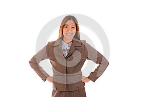 Happy businesswoman in brown suit is smiling and arms akimbo on