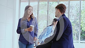 Happy businesswoman and businessman having conversation in modern office.