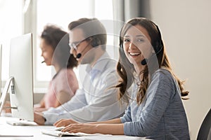 Happy businesswoman call center agent looking at camera at workplace