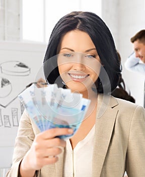 Happy businesswoman with cash money in office photo