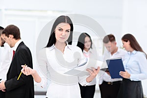 Happy businesswoman with colleagues in the background