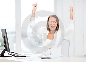 Happy businesswoman with computer in office photo