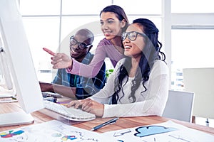 Happy businesswoman explaning to colleagues on computer