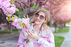 Happy businesswoman holding cherry blossom in park