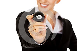 Happy businesswoman holding eight billiard ball. photo