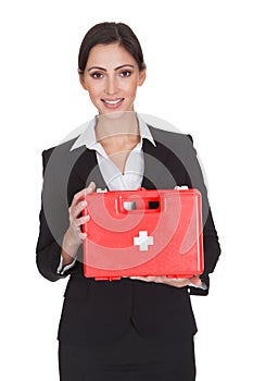 Happy businesswoman holding first aid box